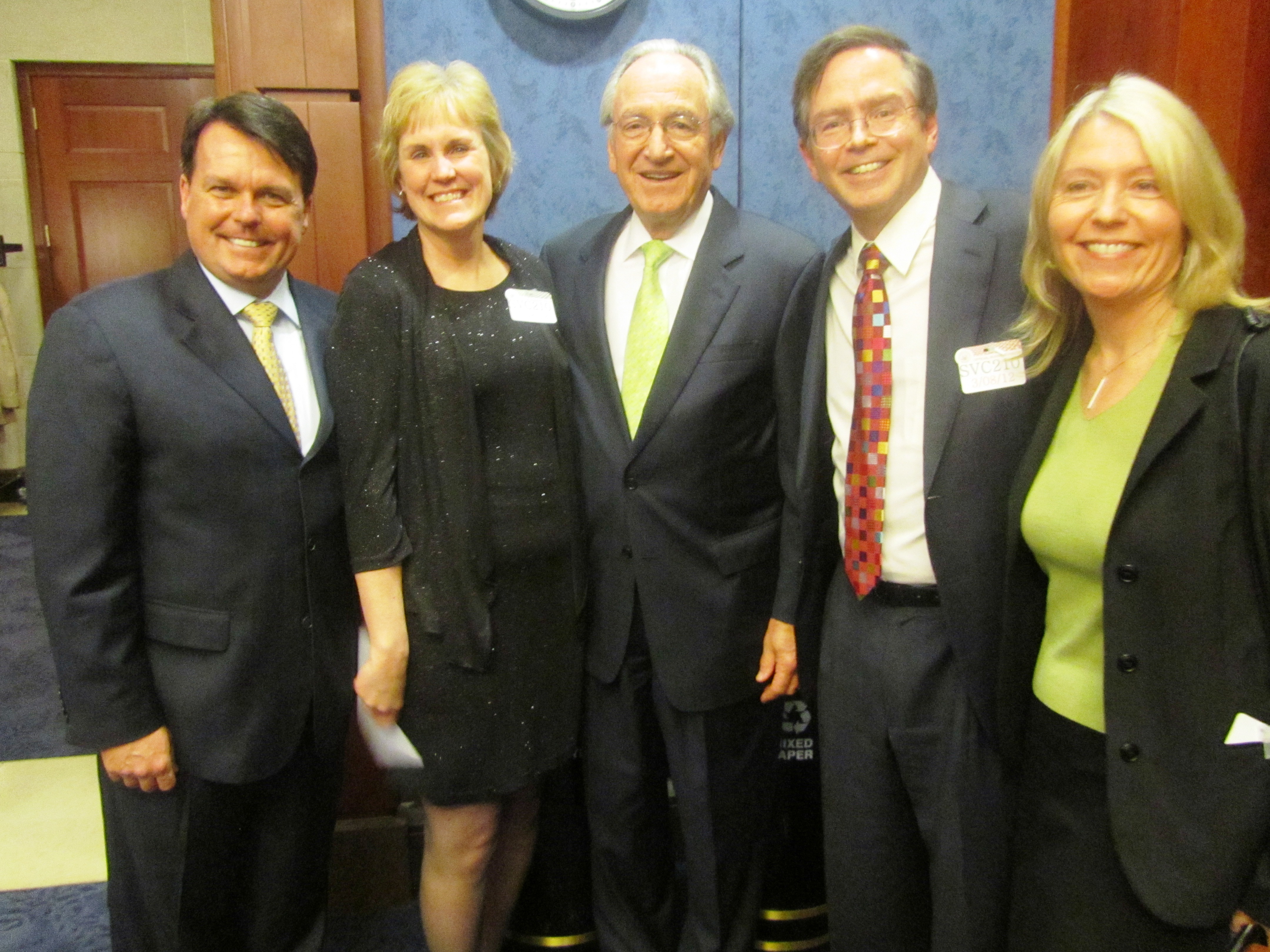 Five individuals standing with Senator Tom Harkin in the middle flanked on his left by Tom Sheridan, Julie Freed, and on his right by Jim Fruchterman and Betsy Beaumon, standing, all in dark suits, 