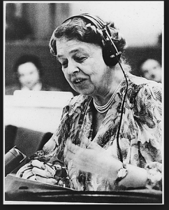 Image of Eleanor Roosevelt with a headset on speaking into a microphone.