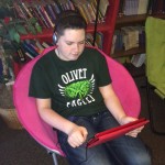 Carson reading a digital book on his iPad with Read2Go app and headphones.