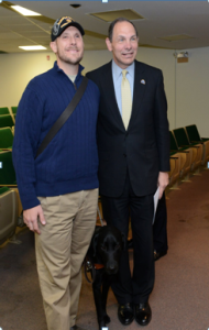 Photo of Secretary of the Department of Veterans Affairs, the Honorable Robert McDonald, Timothy Hornik, and his guide dog Black Jack