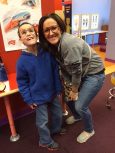 Brennan with his mom, happy that he can read children's books just like all of his sighted classmates.