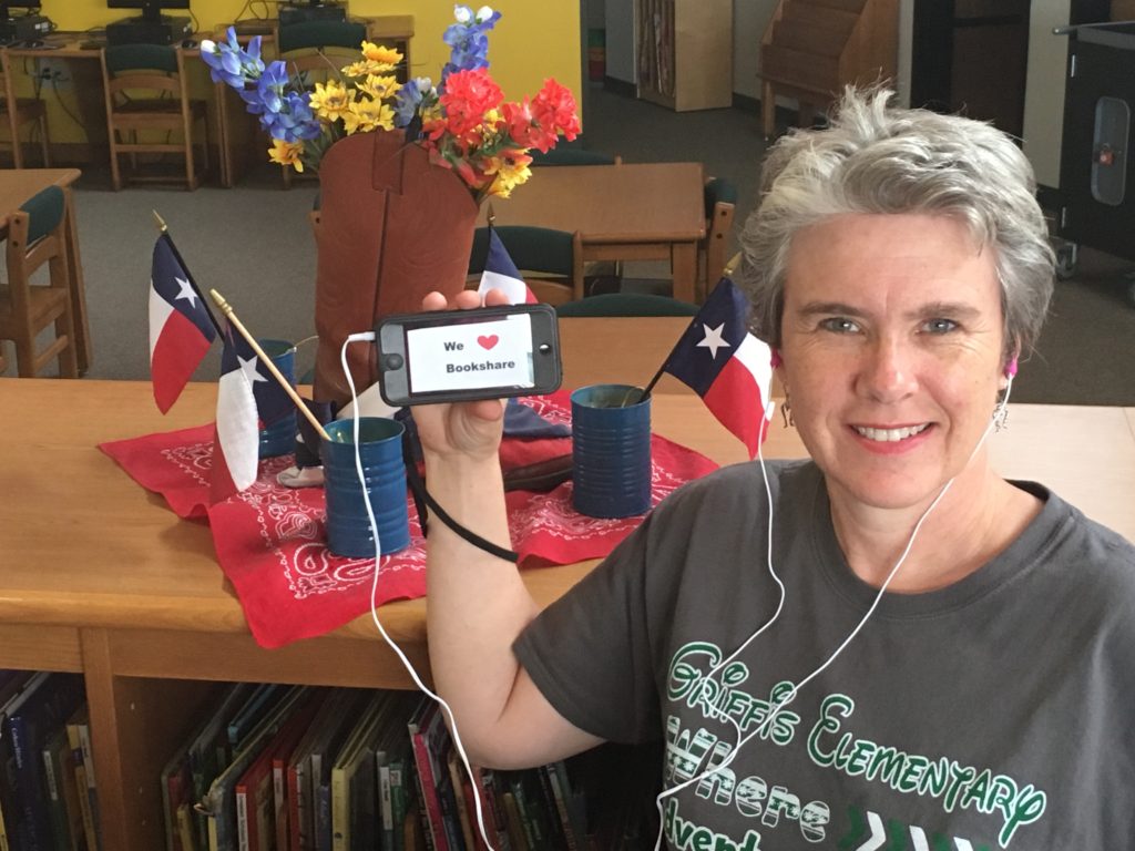 Leslie Patterson listening to a Bookshare book through a smart phone with headphones