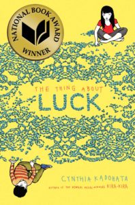 Luck by Cynthia Kadohata: Two children are sitting on the ground.