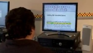 Student at computer reading text with word highlighting