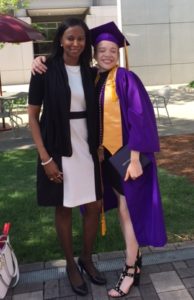 Deirdre Watkins stands next to Sydney who is wearing a graduation cap and gown