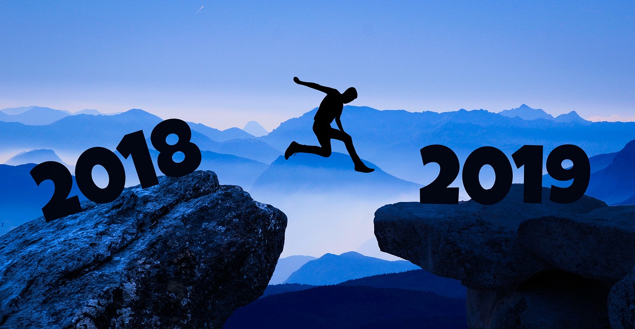man jumping from one rock that says 2018 to another rock that says 2019
