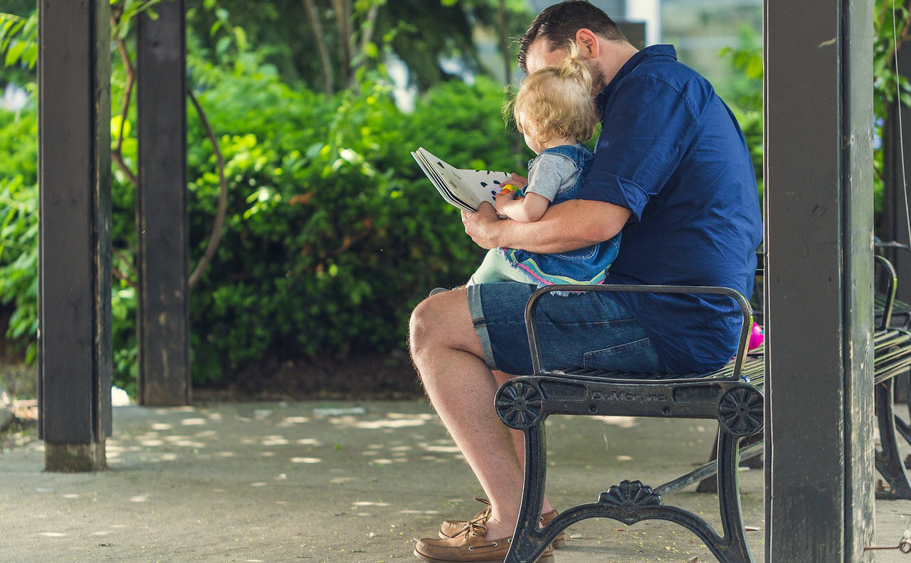 Man reading with child on lap