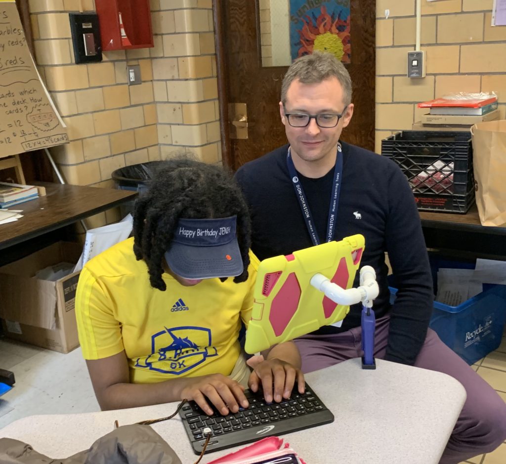 Scott Richards teaches a student to use a keyboard